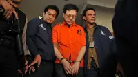 Tubuh Hartawan Aluwi sudah dibalut baju tahanan polisi berwarna oranye saat keluar dari ruang pemeriksaan.