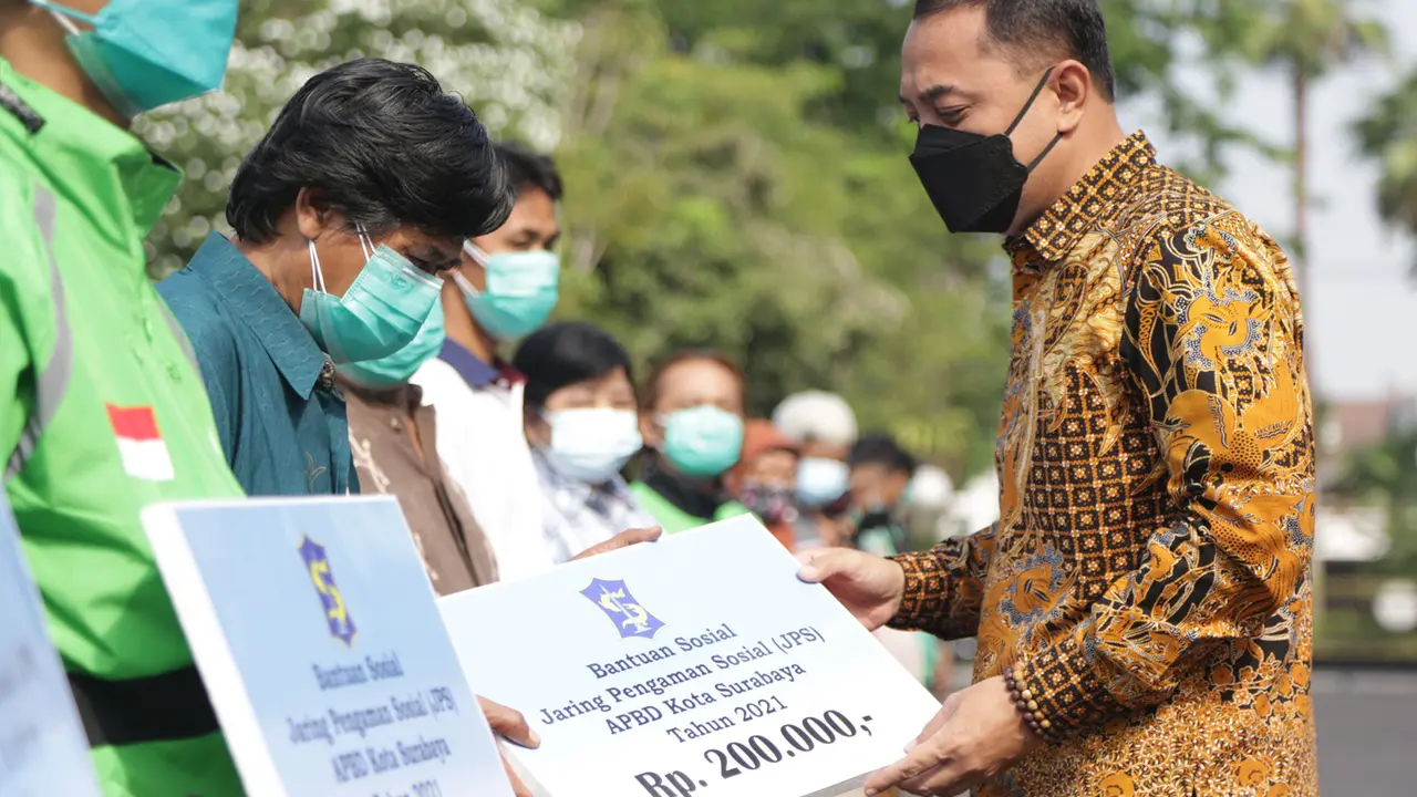 Eri Cahyadi menyerahkan bansos JPS masing-masing senilai Rp 200 ribu kepada 15 MBR di halaman Balai Kota Surabaya. (Dian Kurniawan/Liputan6.com)