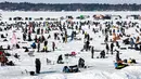 Pemancing di dekat lubang pemancingan saat Brainerd Jaycees Ice Fishing Extravaganza tahunan ke-32 di Gull Lake's Hole di Teluk Day, Minnesota pada 29 Januari 2022. Hampir 10.000 pemancing dari Minnesota dan negara bagian lain menghadiri kontes memancing es amal terbesar di dunia. (Kerem Yucel/AFP)