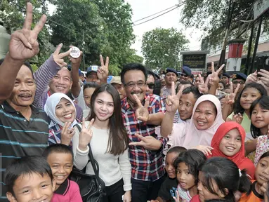 Calon wakil gubernur DKI Jakarta Djarot Saiful Hidayat berfoto bersama warga saat blusukan di Pasar Bedeng, Palmerah, Jakarta Barat, Kamis (24/11). Dalam blusukannya, Djarot berdialog dengan pedagang dan warga di pasar. (Liputan6.com/Yoppy Renato)