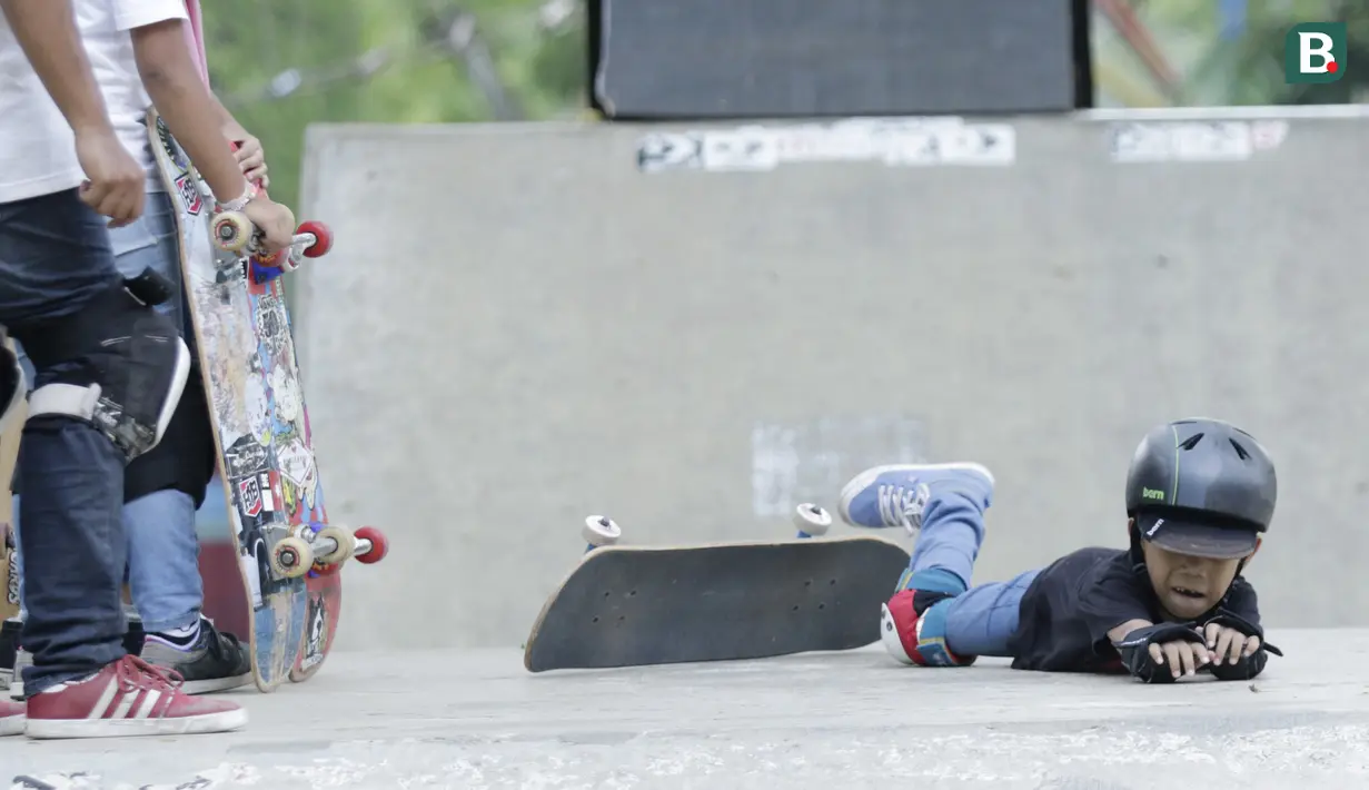 Seorang anak terjatuh saat berlatih skateboard di TMII, Jakarta, Sabtu (8/9/2018). Green Skate Lesson yang didirikan oleh mantan atlet skateboard, Tony Sruntul, merupakan wadah regenerasi skateboarder bertalenta. (Bola.com/M Iqbal Ichsan)