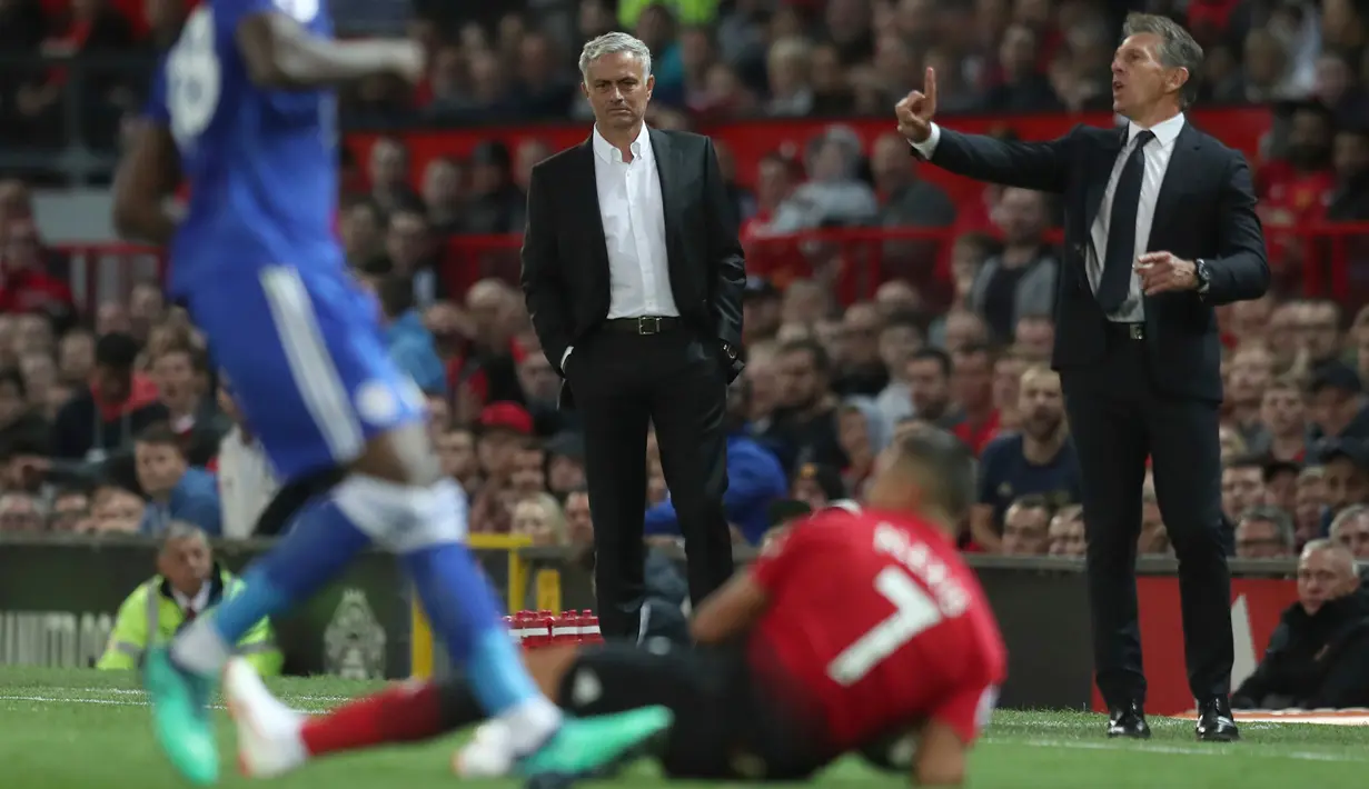 Manajer Leicester City Claude Puel (kanan) yang berdekatan dengan Manajer Manchester United Jose Mourinho (tengah) bereaksi atas keputusan wasit selama pertandingan Premier League Inggris di Old Trafford, Manchester, Jumat (10/8). (AP Photo/Jon Super)