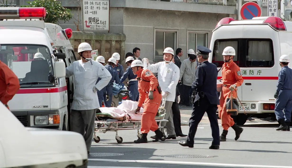 Petugas medis membawa korban ke ambulans setelah serangan gas sarin oleh sekte kiamat Aum Shinrikyo di stasiun kereta bawah tanah Tsukiji, Tokyo, Jepang, 20 Maret 1995. Serangan tersebut menewaskan 13 orang dan melukai ribuan lainnya. (JIJI PRESS/AFP)