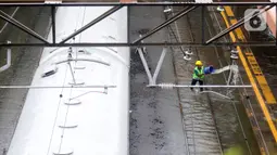 Petugas berusaha mengurangi debit air yang menggenangi rel Stasiun kereta Tanah Abang, Jakarta, Rabu (1/1/2020). Hujan yang mengguyur Jakarta sejak Selasa sore (31/12/2019) mengakibatkan rel terendam dan perjalanan kereta dari dan ke Stasiun Tanah Abang dihentikan. (Liputan6.com/Helmi Fithriansyah)