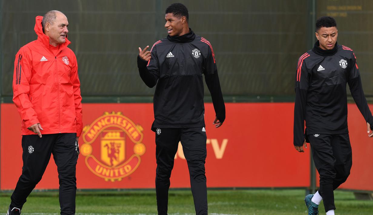 Pemain Manchester United, Marcus Rashford (tengah) berdiskusi dengan asisten pelatih dan Jesse Lingard (kanan) saat menuju tempat latihan di club training complex, Carrington, Manchester, (11/9/2017). MU akan melawan FC Basel di grup A. (AFP/Paul Ellis)