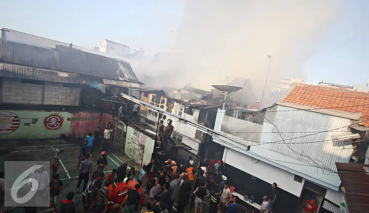 Sejumlah warga menyaksikan kebakaran yang melanda sejumlah rumah di kawasan tanah Abang, Jakarta, Senin (5/9). Belum diketahui penyebab serta kerugian akibat kebakaran yang menghanguskan kawasan padat penduduk tersebut. (Liputan6.com/Immanuel Antonius)