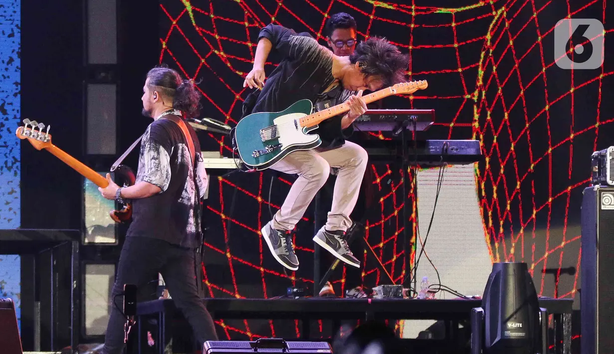 Aksi Gitaris Band Sheila on 7, Eros saat konser yang bertajuk 'Tunggu Aku di Jakarta' di kawasan JIExpo Kemayoran, Jakarta, Sabtu, (28/1/2023). Dalam konser yang bertajuk 'Tunggu Aku di Jakarta', Sheila on 7 membawakan lagu-lagu andalannya seperti Pejantan Tangguh, Pria Kesepian, Sephia dan lain-lain. (Liputan6.com/Herman Zakharia)