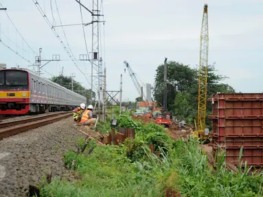  Kereta milintas di dekat proyek pembangunan jalur dua rel ganda atau double-double track (DDT) Manggarai-Cikarang, Jakarta, Jumat (13/1). Menhub mengungkapkan, kendala proyek DDT ini adalah administrasi pembebasan lahan. (Liputan6.com/Gempur M Surya)