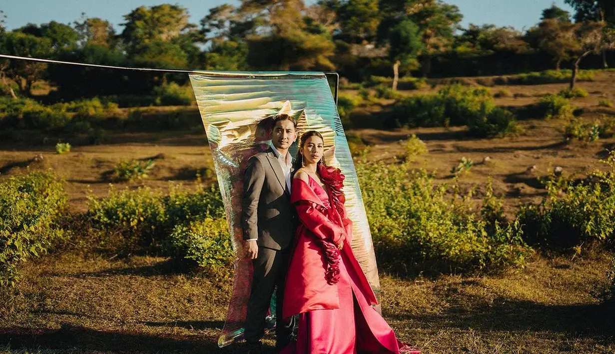 Potret prewedding yang tak kalah menggemaskan dari Adinda Thomas. Ia tampak mengenakan dress merah yang glamor dengan latar kertas emas yang ditaruh di tengah padang rumput. [Foto: Instagram/adindathomas]