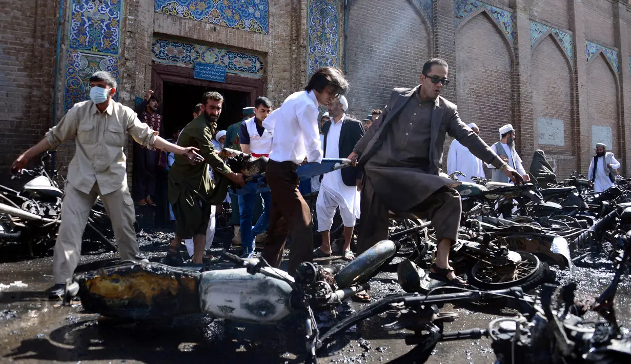 Relawan menggunakan tandu membawa korban ledakan bom yang terjadi di luar masjid bersejarah, Masjid Jami, kota Herat di Afghanistan, Selasa (6/6). Sampai saat ini belum ada kelompok yang mengaku bertanggung jawab akan teror bom itu. (HOSHANG HASHIMI/AFP)