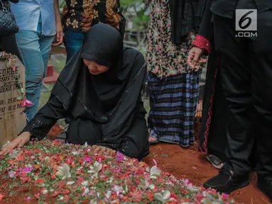 Istri mendiang George Mustafa Taka, Desty Amalia berada di dekat makam suaminya di Komplek Pemakaman Kempo, Jatiwaringin, Pondok Gede, Jakarta, Jumat (2/10). George Mustafa Taka meninggal akibat serangan jantung. (Liputan6.com/Faizal Fanani)