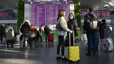 Pelancong menunggu di papan keberangkatan sebelum penerbangan mereka di bandara Boryspil, luar Kiev, 13 Februari 2022. Ukraina berjanji menjaga wilayah udaranya terbuka untuk perjalanan internasional setelah negara Barat memperingatkan pasukan Rusia dapat menyerang kapan saja. (Sergei Supinsky/AFP)