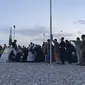 Orang-orang Afghanistan mengantre naik pesawat militer AS untuk meninggalkan Afghanistan, di bandara militer di Kabul, Kamis (19/8/2021). Ribuan orang berlomba-lomba melarikan diri dari Afghanistan setelah pasukan Taliban berhasil merebut pemerintahan negara itu. (Shakib RAHMANI/AFP)