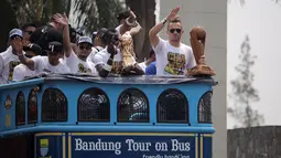 Pemain Persib, Ilija Spasojevic (kanan) memegang Piala Presiden diatas Bus Bandung Tour on Bus (Bandros) dalam Pawai Persib Juara Piala Presiden saat start dari Kota Baru Parahyangan, Bandung, Minggu (25/10/2015). (Bola.com/Nick Hanoatubun)