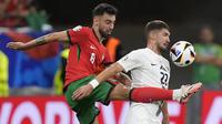 Gelandang Portugal Bruno Fernandes mencoba tendang bola yang dihalangi gelandang Slovenia, Cerin pada laga 16 besar Euro 2024 (AP)