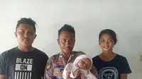 Polisi NTT, Brigpol Alfred Nikodemus Dimu berfoto bersama bayi yang dia selamatkan dan kedua orang tuanya. (Foto: Liputan6.com/Ola Keda)