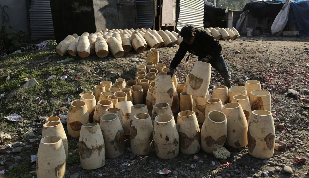 Seorang pria mengatur genderang  tradisional untuk dikeringkan di daerah kumuh di Jammu, India (19/1/2021). Genderang tradisional ini digunakan terutama saat pernikahan dan prosesi keagamaan. (AP Photo / Channi Anand)
