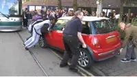 Ramai-ramai Angkat Mobil Halangi Rel Trem