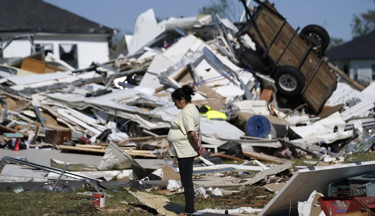 Bertelina Martinez, yang tinggal di dekatnya dan putranya yang tinggal di seberang jalan, melihat-lihat kehancuran setelah tornado melanda daerah di Arabi, La., Rabu (23/3/2022). (AP Photo/Gerald Herbert)