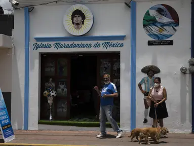 Turis berfoto di depan Gereja Maradona di San Andres Cholula, negara bagian Puebla, Meksiko, Minggu (18/7/2021). Gereja Maradona di Meksiko didedikasikan untuk mendiang legenda sepak bola asal Argentina Diego Armando Maradona. (AP Photo/Marco Ugarte)