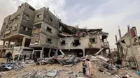 Anak-anak berdiri di luar gedung keluarga Sabah yang terkena serangan udara Israel di Deir el-Balah, Jalur Gaza tengah pada 8 April 2025. (Eyad BABA/AFP)
