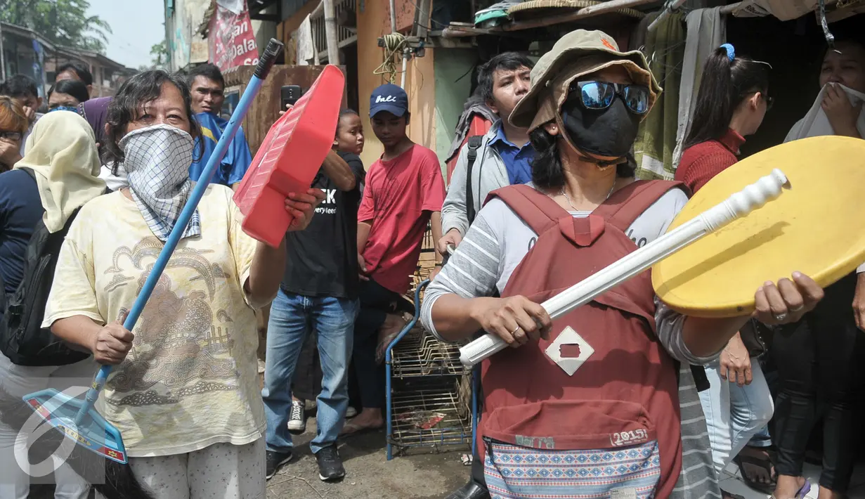 Warga memukul peralatan rumah tangga saat proses penggusuran permukiman di bantaran Kali Ciliwung Jakarta, Rabu (28/9). Pemprov DKI meratakan pemukiman warga Bukit Duri terkait revitalisasi sungai Ciliwung. (Liputan6.com/Yoppy Renato)