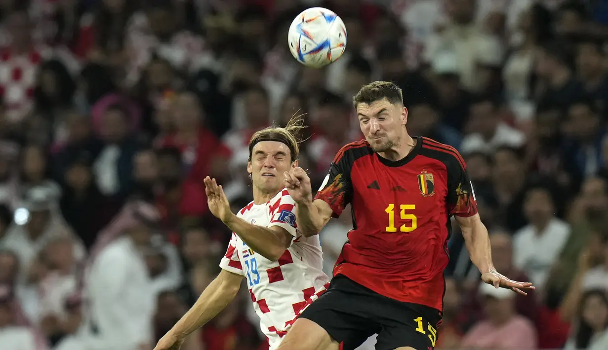 <p>Pemain Belgia, Thomas Meunier (kanan) berebut bola dengan pemain Kroasia, Borna Sosa saat matchday ketiga Grup F Piala Dunia 2022 yang berlangsung di Ahmad Bin Ali Stadium, Kamis (01/12/2022). (AP/Francisco Seco)</p>