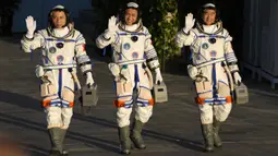 (kiri-kanan) Astronaut China Tang Hongbo, Nie Haisheng, dan Liu Boming melambai saat bersiap untuk lepas landas dari Pusat Peluncuran Satelit Jiuquan, China, Kamis (17/6/2021). Para astronaut menuju Tianhe, modul awal stasiun ruang angkasa Tiangong (Istana Surgawi) China. (AP Photo/Ng Han Guan)