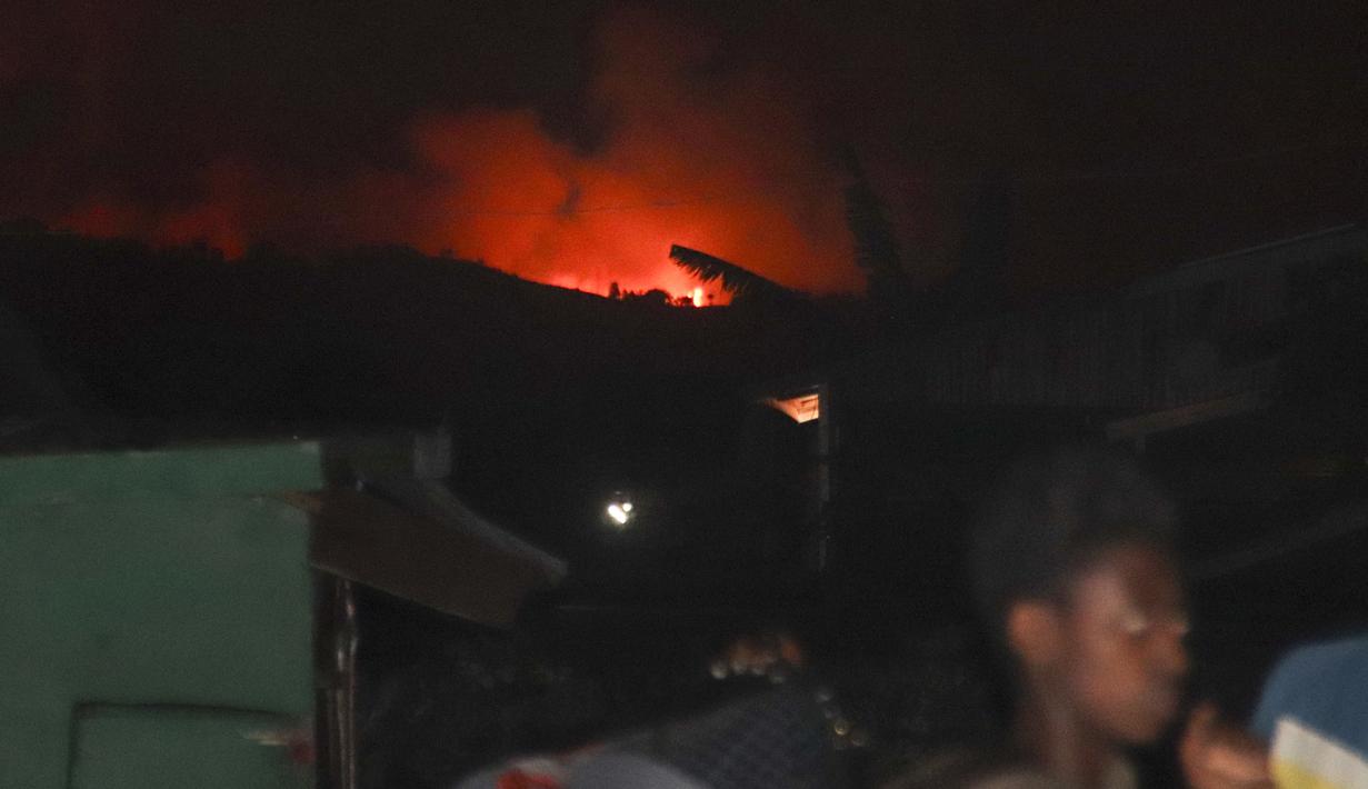 Orang-orang mengungsi karena langit malam berubah merah akibat letusan Gunung Nyiragongo di Goma, Kongo, Sabtu (22/5/2021). Gunung Nyiragongo terakhir meletus pada 17 Januari 2002, menewaskan lebih dari seratus orang dan menutupi hampir semua bagian timur Goma dengan lahar. (AP Photo/Justin Kabumba)