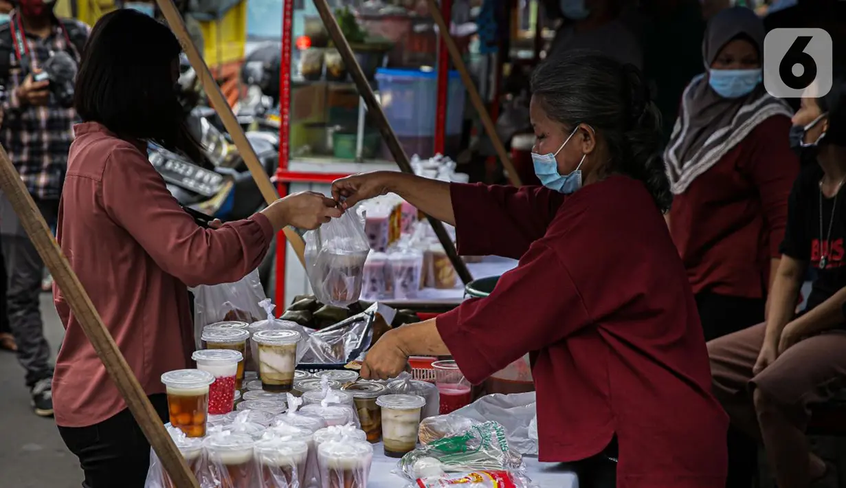 Pedagang melayani pembeli di Pasar Takjil Benhil, Jakarta, Selasa (13/4/2021). Pasar takjil yang ada setiap bulan Ramadhan tersebut dipadati warga untuk membeli makanan berbuka puasa. (Liputan6.com/Faizal Fanani)