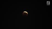 Foto fenomena gerhana bulan total di kota Jakarta, Sabtu (28/7). Gerhana bulan total "Micro Blood Moon" tersebut merupakan yang terlama pada abad ini dengan total waktu termasuk fase penumbra dan parsial selama enam jam lebih. (Liputan6.com/Johan Tallo)