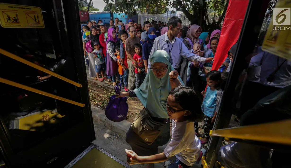 Warga menaiki bus City Tour di kawasan Masjid Istiqlal, Jakarta, Senin (25/12). Libur panjang natal membuat animo warga menggunakan bus City Tour naik drastis. (Liputan6.com/Faizal Fanani)