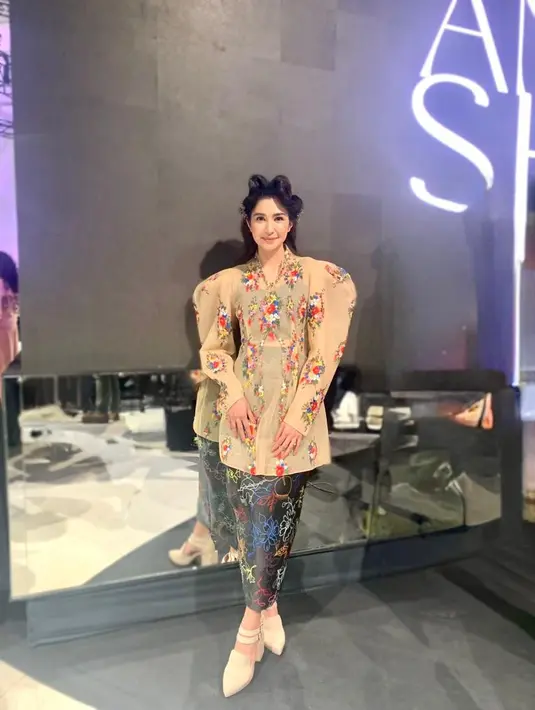 Mikha mengenakan set crop top dan pencil skirt yang dipadukan dengan blouse semi transparan dengan aksen puff sleeve dan motif bunga yang cantik. Rambutnya ditata bergaya retro yang dihiasi dengan hair clip. [Fimela/Hilda Irach]
