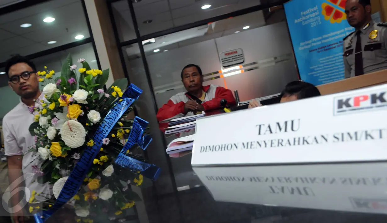 Seorang aktivis membawa karangan bunga yang dihiasi kerupuk saat berkunjung ke KPK, Jakarta, Rabu (16/12/2015). Mereka menolak RUU KPK dan berharap KPK tak melempem seperti kerupuk. (Liputan6.com/Helmi Afandi)
