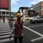 Petugas mengatur lalu lintas untuk warga menyeberang jalan menggunakan pelican crossing di kawasan Glodok, Jakarta, Sabtu (22/1/2022). PT Transportasi mulai mengoperasikan Halte Glodok baru dengan rute Blok M - Kota (Koridor 1). (Liputan6.com/Johan Tallo)