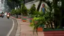 Warga melintasi pedestrian di Jalan TB Simatupang, Jakarta, Jumat (7/7). Pedestrian di Jalan TB Simatupang sekitar perempatan Pasar Rebo menjadi berwarna dengan tampilan pot cat warna warni. (Liputan6.com/Helmi Fithriansyah)