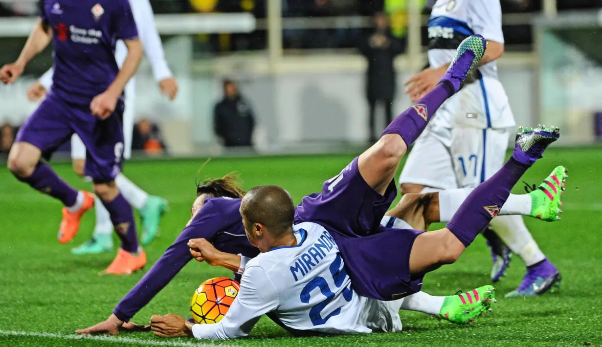 Pemain Fiorentina, Federico Bernardeschi (kiri), terjatuh saat berebut bola dengan pemain Inter, Miranda, dalam laga Serie A Italia di Stadion di Artemio Franchi, Firenze, Senin (15/2/2016) dini hari WIB. (EPA/Maurizio Degl' Innocenti)
