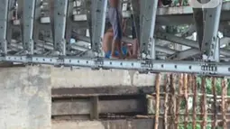 Anak-anak berdiri di jembatan saat berenang di Sungai Ciliwung, Rawajati, Jakarta, Selasa (17/12/2019). Meski debit air Sungai Ciliwung naik akibat hujan mengguyur Jakarta sejak siang hingga sore, anak-anak tersebut tetap nekat berenang tanpa memedulikan keselamatan. (Liputan6.com/Immanuel Antonius)