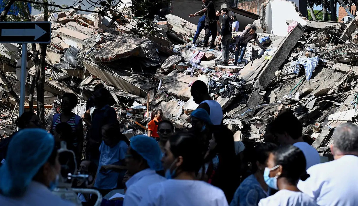 Sejumlah orang mencari korban yang tertimbun  bangunan yang runtuh akibat gempa bumi di Cali, Kolombia, Senin, 10 Agustus 2026 (AFP/ Joaquin Sarmiento)