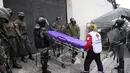 Seorang pekerja Palang Merah menunggu dengan tandu di luar Pusat Penahanan Sementara Nomor 1 di mana terjadi kerusuhan di Quito, Ekuador (25/10/2021). Pihak berwenang melaporkan beberapa narapidana terluka. (AP Photo/Dolores Ochoa)