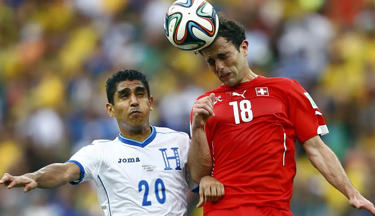 Pemain depan Swiss, Admir Mehmedi (kanan) berebut bola dengan gelandang Honduras, Jorge Claros, di laga penutup penyisihan Piala Dunia 2014 Grup E di Stadion Amazonia, Manaus, Brasil, (26/6/2014). (REUTERS/Dominic Ebenbichler)