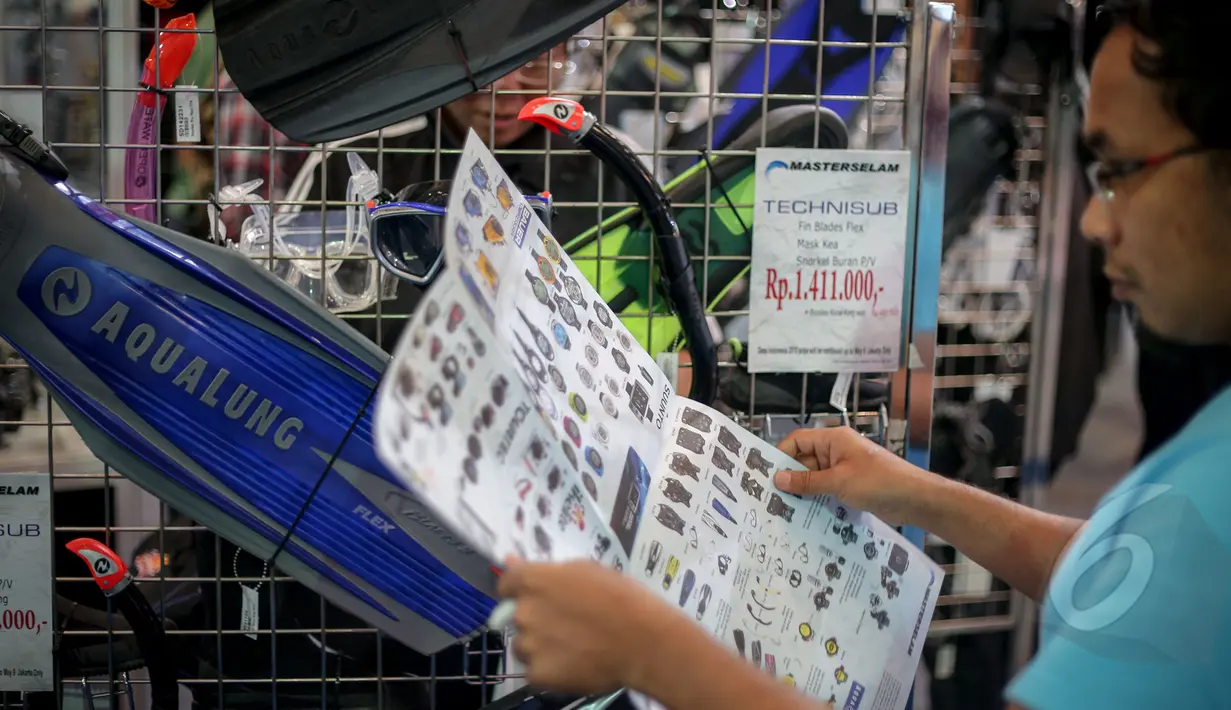 Seorang pengunjung melihat katalog saat kunjungi Deep & Extreme Indonesia 2015, JCC Jakarta, Kamis (30/04/2015). Dalam pameran ini dihadirkan informasi dan perlengkapan dunia selam dan destinasi pariwisata. (Liputan6.com/Faizal Fanani)