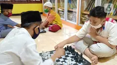 Anak-anak bermain catur di Rumah Amalia, Kota Tangerang, Selasa (23/03/2021). Selama pandemi Covid-19, rumah belajar bagi anak yatim dan dhuafa ini mengajak anak-anak bermain catur sebagai bentuk terapi agar bisa relaksasi dan mengurangi depresi selama di rumah. (Liputan6.com/Fery Pradolo)