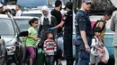 Para migran bersiap naik bus selama operasi polisi di pusat Athena, Yunani (19/9/2019). Polisi di Athena pada 19 September 2019 memindahkan lebih dari 200 migran, termasuk lusinan anak-anak, dari dua tempat di pusat kota sebagai bagian dari pembersihan. (AFP Photo/Louisa Gouliamaki)