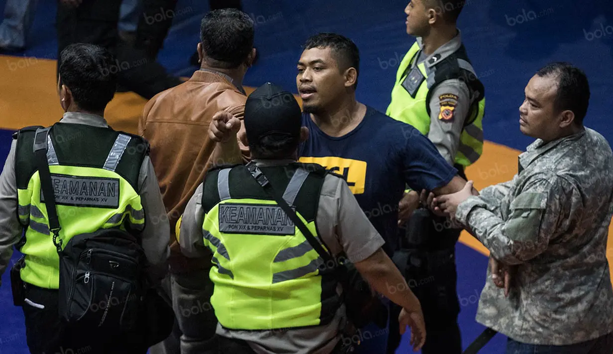 Rekan dari Agus Setia masuk ke arena dan meminta agar pihak keamanan melepas sang pegulat. (Bola.com/Vitalis Yogi Trisna)