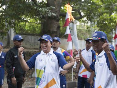 Legenda olahraga Indonesia, Ellyas Pical dan Sutiyono, saat pawai obor Asian Games 2018 di Bogor, Jawa Barat, Selasa (14/8/2018). Api obor yang datang dari Cianjur itu langsung diarak mengelilingi jalanan protokol Kota Bogor. (Bola.com/Reza Bachtiar)