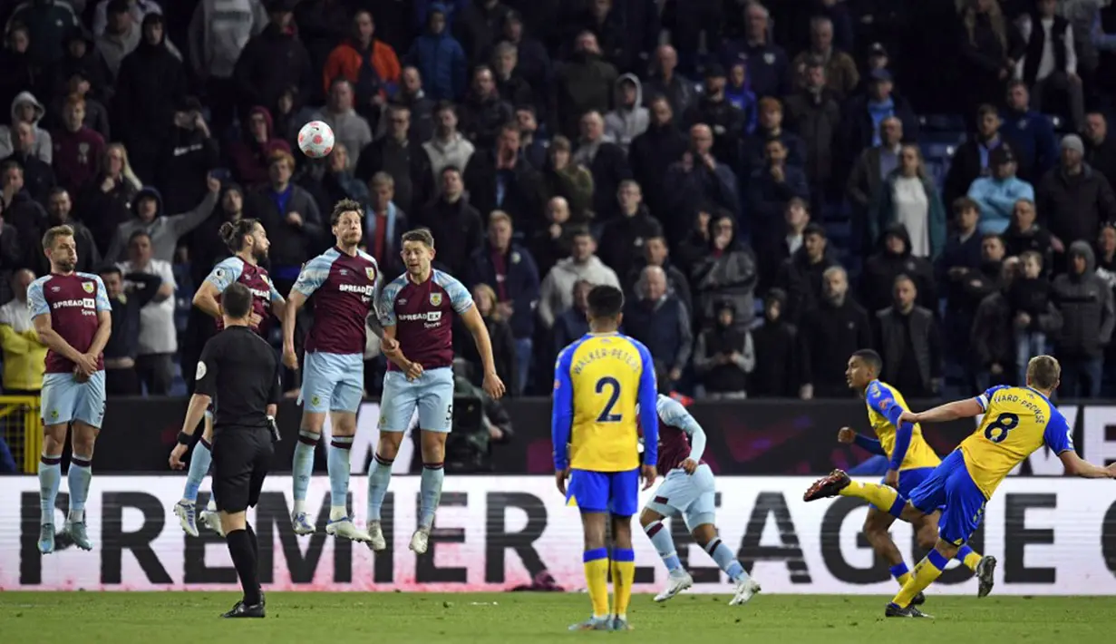 <p>Pemain Southampton James Ward-Prowse (kanan) melakukan tendangan bebas saat melawan Burnley pada pertandingan Liga Inggris di Turf Moor, Burnley, Inggris, 21 April 2022. Burnley menang 2-0. (Oli SCARFF/AFP)</p>