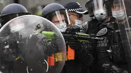 Polisi mengenakan pakaian anti huru hara selama protes anti-lockdown di Melbourne, Australia, Sabtu (21/8/2021). Para pengunjuk rasa berunjuk rasa menentang pembatasan pemerintah yang ditempatkan dalam upaya mengurangi wabah COVID-19. (James Ross/AAP Image via AP)