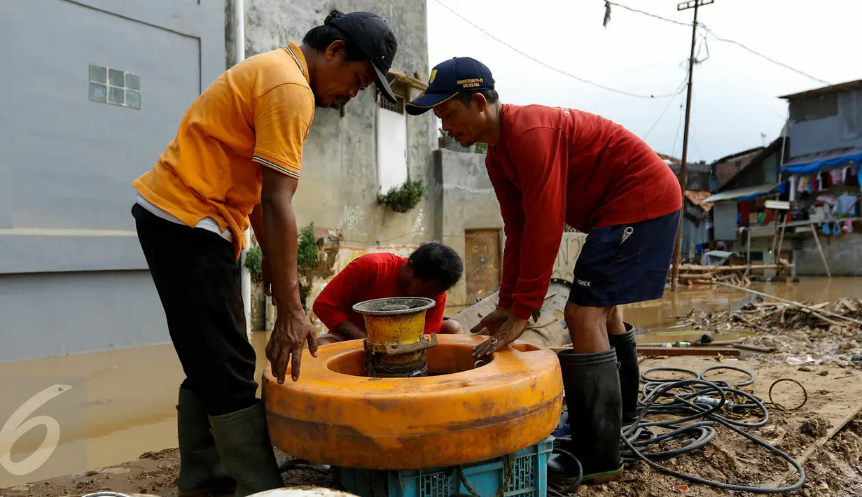 Petugas normalisasi Ciliwung menyiapkan pompa penguras air, Kampung Pulo, Jakarta, Rabu (25/11/2015). Pompa tersebut untuk mempercepat penyurutan banjir di pemukiman Kampung Pulo. (Liputan6.com/Yoppy Renato)