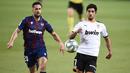 Gelandang Valencia, Goncalo Guedes, berebut bola dengan bek Levante, Jorge Miramon, pada laga pekan ke-28 Liga Spanyol di Stadion Mestalla, Sabtu (13/6/2020) dini hari WIB. Valencia bermain imbang 1-1 atas Levante. (AFP/Jose Jordan)